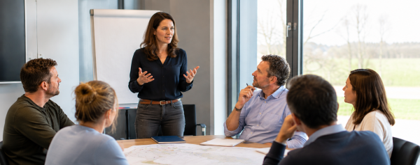 Trainer begeleidt bouw- en infraprofessionals tijdens een interactieve communicatietraining